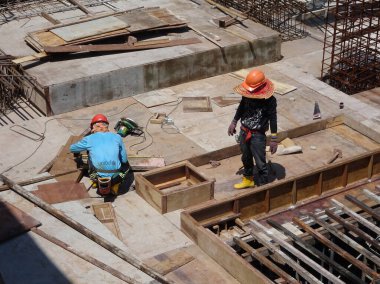 KUALA LUMPUR, MALAYSIA - 16 Temmuz 2017: Marangozlar inşaat alanında kereste ve kontrplak formları üretirler. Güçlendirilmiş beton yapının kalıbı olarak ahşap biçimlendirme.