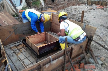 KUALA LUMPUR, MALAYSIA - 16 Temmuz 2017: Marangozlar inşaat alanında kereste ve kontrplak formları üretirler. Güçlendirilmiş beton yapının kalıbı olarak ahşap biçimlendirme.