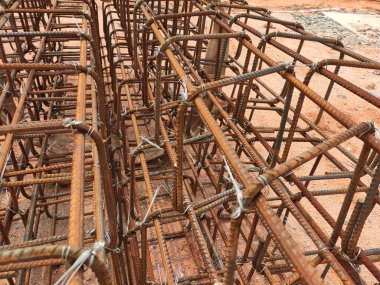 SEREMBAN, MALAYSIA - 29 Mart 2020: İnşaat işçileri inşaat alanında çelik takviye çubuğu üretiyorlar. Formatörleri kullanmadan önce küçük kabloları kullanarak birbirlerine bağladılar.. 