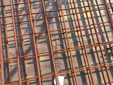 SEREMBAN, MALAYSIA - 29 Mart 2020: İnşaat işçileri inşaat alanında çelik takviye çubuğu üretiyorlar. Formatörleri kullanmadan önce küçük kabloları kullanarak birbirlerine bağladılar.. 