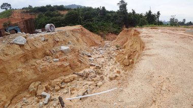 Şiddetli yağmur nedeniyle toprak kayması. Heyelan yeraltı su borularını yok ediyor ve bazı insanlar binalar inşa ediyor.. 