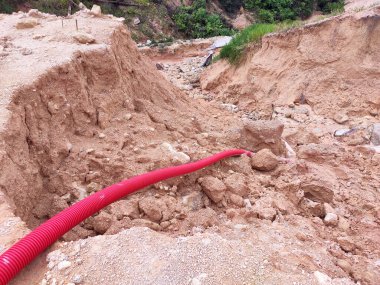 Şiddetli yağmur nedeniyle toprak kayması. Heyelan yeraltı su borularını yok ediyor ve bazı insanlar binalar inşa ediyor.. 