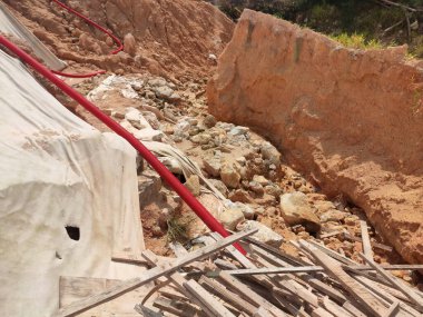 Şiddetli yağmur nedeniyle toprak kayması. Heyelan yeraltı su borularını yok ediyor ve bazı insanlar binalar inşa ediyor.. 