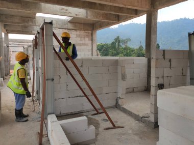 SEREMBAN, MALAYSIA -MARCH 17, 2020: Blockwork by construction workers at the construction site. Workers laying the AAC brick and stacked it together using mortar to form the wall. 