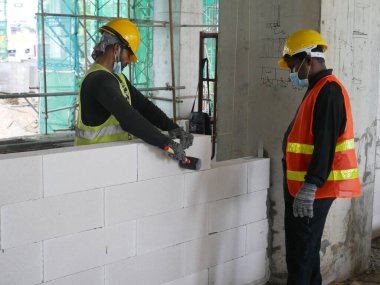 SEREMBAN, MALAYSIA -MARCH 17, 2020: Blockwork by construction workers at the construction site. Workers laying the AAC brick and stacked it together using mortar to form the wall. 