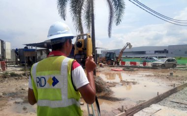 MALACCA, MALAYSIA - 16 Temmuz 2017: İnşaat alanında araştırma ekipmanları ile araştırmacı. Seviyeyi belirlemek ve kontrol etmek için bu ekipmanı kullanıyor..   