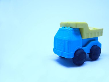 Beyaz arka planda izole edilmiş renkli sentetik kauçuktan yapılmış inşaat kamyonunun minyatür modeli.. 