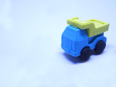 Beyaz arka planda izole edilmiş renkli sentetik kauçuktan yapılmış inşaat kamyonunun minyatür modeli.. 