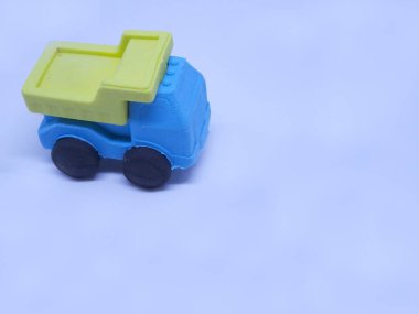 Beyaz arka planda izole edilmiş renkli sentetik kauçuktan yapılmış inşaat kamyonunun minyatür modeli.. 