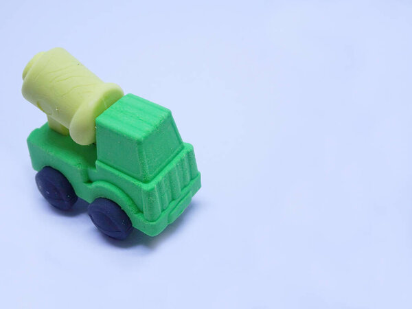 A miniature model of construction concrete mixer lorry made from colourful sticky synthetic rubber isolated on white background. 