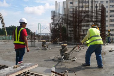 KUALA LUMPUR, MALAYSIA - 17 Temmuz 2020: Şantiyedeki inşaat işçilerinin elektrik şamandırası çalışmaları. Elektrik şamandırası ıslak betonu düzleştirmek için kullanılmış.. 