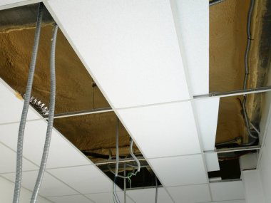 KUALA LUMPUR, MALAYSIA - 24 Temmuz 2020: Askıdaki tavan, elektrik kabloları, kablolama ve mekanik ekipmanlar kurulum altında. - Zeminde asılı duruyor. Tavan panosuna göre kapla. 