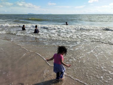 Mersin, Malezya - 12 Ocak 2020: gündüzleri tropik plaj. Çocuklar ve yetişkinler tropik plajda banyo yaparken eğleniyorlar. Deniz suyu kristal kadar berrak ve kirlilik yok..