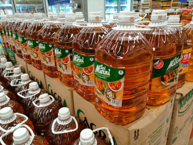 SEREMBAN, MALAYSIA -APRIL 26, 2020: Plastik kapta paketlenmiş ve süpermarkette satışa sunulan işlenmiş palmiye tohumundan yapılan pişirme yağına odaklanmış. 