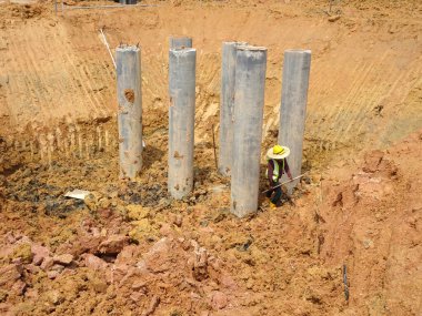 IPOH, MALAYSIA -MARCH 03, 2020:  Bore pile materials made from strong precast concrete designed by the engineers. It will be driven into the soil as the foundation and will be tied by pile caps. clipart