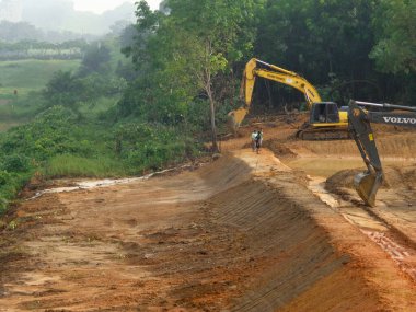 CYBERJAYA, MALAYSIA - HAZİRAN 8, 2020: Yeni gelişim alanı için toprak çalışmaları. Gerekli seviyeyi elde etmek için orman temizliği ve toprak işleri yapan ağır makineler.