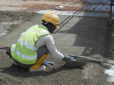 MALACCA, MALAYSIA -MAC 16, 2017: İnşaat işçileri inşaat alanında kumu dengeleyecekler. Beton kaldırımları kurmadan önce kumu altyapı olarak kullanın. 