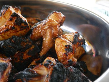 Izgara yapılmış ve servis edilmeye hazır tavuk parçaları. Izgara yapılmadan önce özel baharatlarla tatlandırılmış..