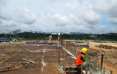 JOHOR, MALAYSIA -18 Ocak 2017: Johor, Malezya 'daki inşaat alanında çelik takviye barı üreten inşaat işçileri. Destek çubuğu ince kabloyla birbirine bağlıydı.. 