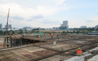 JOHOR, MALAYSIA -18 Ocak 2017: Johor, Malezya 'daki inşaat alanında çelik takviye barı üreten inşaat işçileri. Destek çubuğu ince kabloyla birbirine bağlıydı.. 