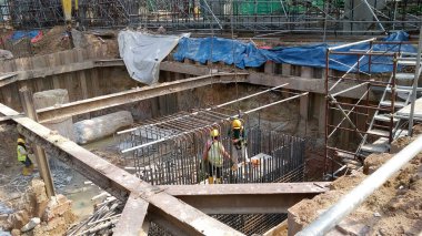 JOHOR, MALAYSIA -18 Ocak 2017: Johor, Malezya 'daki inşaat alanında çelik takviye barı üreten inşaat işçileri. Destek çubuğu ince kabloyla birbirine bağlıydı.. 
