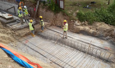 JOHOR, MALAYSIA -18 Ocak 2017: Johor, Malezya 'daki inşaat alanında çelik takviye barı üreten inşaat işçileri. Destek çubuğu ince kabloyla birbirine bağlıydı.. 