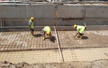 JOHOR, MALAYSIA -18 Ocak 2017: Johor, Malezya 'daki inşaat alanında çelik takviye barı üreten inşaat işçileri. Destek çubuğu ince kabloyla birbirine bağlıydı.. 