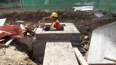 MALACCA, MALAYSIA - 25 Mart 2017: İnşaat işçileri Malacca, Malezya 'daki inşaat sahasına yeraltı önceden yapılmış beton drenaj döşemesi kurdular.  