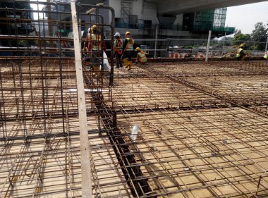 SEREMBAN, MALAYSIA - 2 Ağustos 2016: İnşaat alanında çalışan işçilerin ürettiği kereste ve çelik takviye çubuğu 