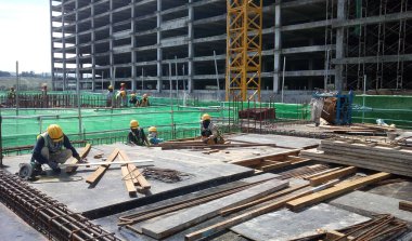 SEREMBAN, MALAYSIA - 2 Ağustos 2016: İnşaat alanında çalışan işçilerin ürettiği kereste ve çelik takviye çubuğu 