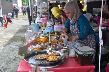 KUALA LUMPUR, MALAYSIA - 5 Mart 2020: Sokak satıcıları ve satıcıları halka yerel mal ve yiyecek satıyorlar. Yoldan geçenlere, kulübelerine uğramaları için seslendiler..