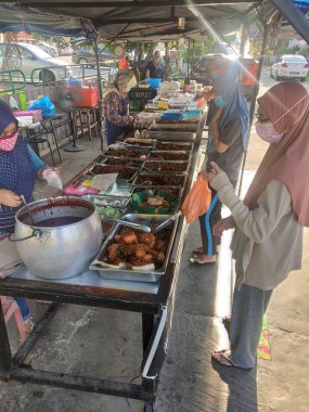 KUALA LUMPUR, MALAYSIA - 5 Mart 2020: Sokak satıcıları ve satıcıları halka yerel mal ve yiyecek satıyorlar. Yoldan geçenlere, kulübelerine uğramaları için seslendiler..