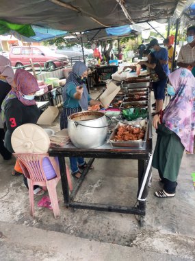 KUALA LUMPUR, MALAYSIA - 5 Mart 2020: Sokak satıcıları ve satıcıları halka yerel mal ve yiyecek satıyorlar. Yoldan geçenlere, kulübelerine uğramaları için seslendiler..