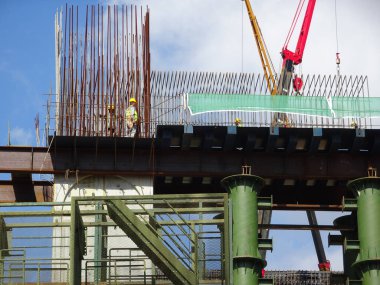 MALACCA, MALAYSIA - 14 Mart 2020: İnşaat işçileri inşaat alanında yükseklerde çalışıyor. Kaza yapmalarını önlemek için onlara emniyet kemeri ve diğer güvenlik ekipmanları sağlanıyor..