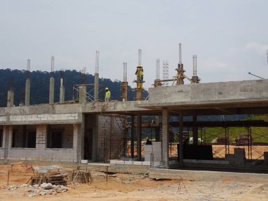 MALACCA, MALAYSIA - 14 Mart 2020: İnşaat işçileri inşaat alanında yükseklerde çalışıyor. Kaza yapmalarını önlemek için onlara emniyet kemeri ve diğer güvenlik ekipmanları sağlanıyor..