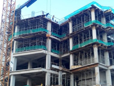 MALACCA, MALAYSIA - 14 Mart 2020: İnşaat işçileri inşaat alanında yükseklerde çalışıyor. Kaza yapmalarını önlemek için onlara emniyet kemeri ve diğer güvenlik ekipmanları sağlanıyor..