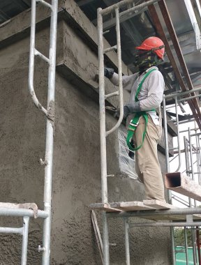 MALACCA, MALAYSIA - 14 Mart 2020: İnşaat işçileri inşaat alanında yükseklerde çalışıyor. Kaza yapmalarını önlemek için onlara emniyet kemeri ve diğer güvenlik ekipmanları sağlanıyor..