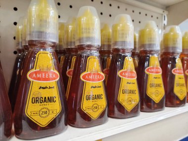 KUALA LUMPUR, MALAYSIA - 20 Kasım 2020: plastik kaplarda saf bal. Süpermarketin içindeki rafta satılık..  