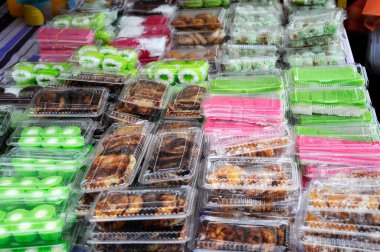 Malezya kekleri masada satışta. Müşterilerin satın almasını kolaylaştıracak türlere göre sırala.