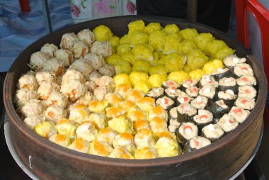 Dim Sum ahşap buharlı tencerede çok çeşitli zevkleri var. Dim Sum ünlü Çin yemeklerinden biridir. Yüksek sıcaklıkta buharla pişirilir.. 