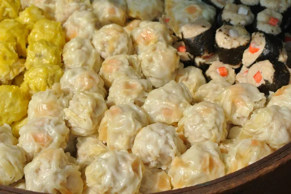 Dim Sum with miscellaneous taste in wooden steam cooker. Dim Sum is one of the famous Chinese food. It is cooked by steam at a high temperature.