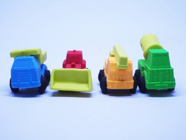 Beyaz arka planda izole edilmiş renkli sentetik kauçuktan yapılmış ağır makinenin minyatür modeli. 