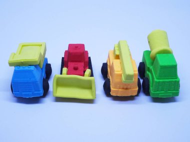 Beyaz arka planda izole edilmiş renkli sentetik kauçuktan yapılmış ağır makinenin minyatür modeli. 