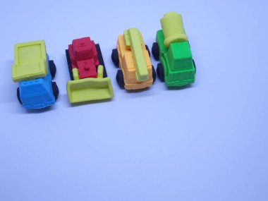 Beyaz arka planda izole edilmiş renkli sentetik kauçuktan yapılmış ağır makinenin minyatür modeli. 