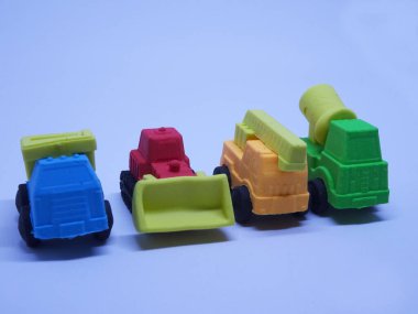 Beyaz arka planda izole edilmiş renkli sentetik kauçuktan yapılmış ağır makinenin minyatür modeli. 