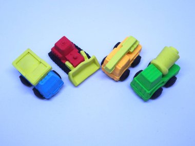 Beyaz arka planda izole edilmiş renkli sentetik kauçuktan yapılmış ağır makinenin minyatür modeli. 