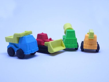 Beyaz arka planda izole edilmiş renkli sentetik kauçuktan yapılmış ağır makinenin minyatür modeli. 