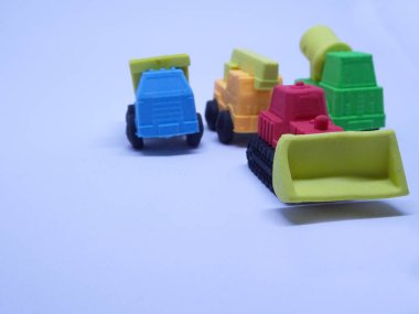 Beyaz arka planda izole edilmiş renkli sentetik kauçuktan yapılmış ağır makinenin minyatür modeli. 