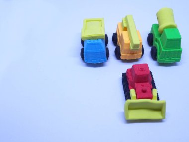 Beyaz arka planda izole edilmiş renkli sentetik kauçuktan yapılmış ağır makinenin minyatür modeli. 