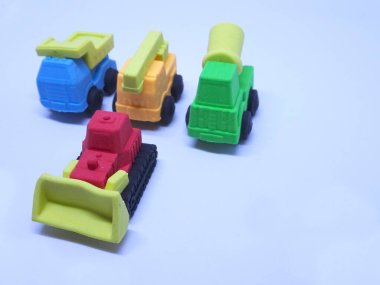 Beyaz arka planda izole edilmiş renkli sentetik kauçuktan yapılmış ağır makinenin minyatür modeli. 